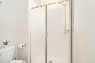 a shower with a glass door in a bathroom at 4393MO TOWNHOUSE 5 BEDROOMS & 4 BATHROOMS + POOL in Kissimmee