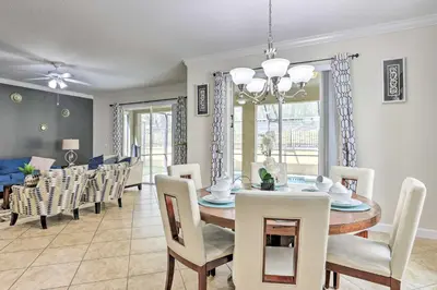 a dining room and living room with a table and chairs at Paradise Palms Home with Pool, 6 Mi to Disney! in Kissimmee