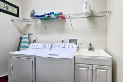 a laundry room with a washing machine and a sink at Paradise Palms Home with Pool, 6 Mi to Disney! in Kissimmee
