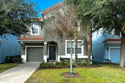 a house with a tree in front of it at Paradise Palms Home with Pool, 6 Mi to Disney! in Kissimmee