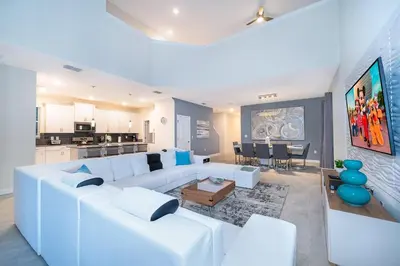 a living room with a white couch and a kitchen at 2811AS VILLA 5 BED/5 BA (SANITIZED) in Kissimmee