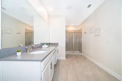 a bathroom with a sink and a large mirror at 2811AS VILLA 5 BED/5 BA (SANITIZED) in Kissimmee