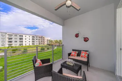 a balcony with chairs and a couch and a view of a building at 3180-201JB STOREY LAKE, CONDO 3/2 GARDEN VIEW in Kissimmee