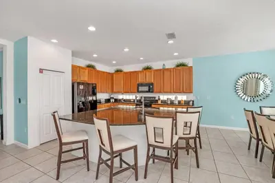 a kitchen with a large island with chairs in it at Stunning LAKE VIEW, Big Pool Area with CDC Standards #6BV507 in Kissimmee