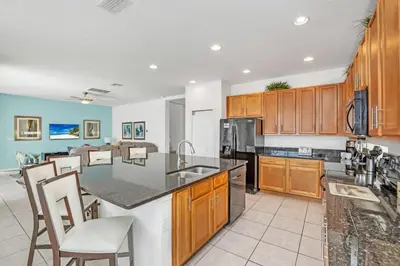 a kitchen with wooden cabinets and a counter top at Stunning LAKE VIEW, Big Pool Area with CDC Standards #6BV507 in Kissimmee