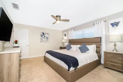 a bedroom with a bed and a flat screen tv at 3151LS TOWNHOUSE 4 BEDROOMS & 3 BATHROOMS + POOL in Kissimmee