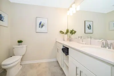 a white bathroom with a toilet and a sink at 3180-103EF STOREY LAKE, CONDO 2/2 GARDEN VIEW in Kissimmee