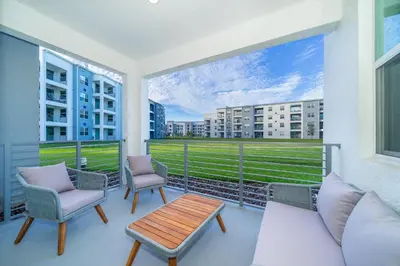 a balcony with a couch and chairs and a table at 3180-103EF STOREY LAKE, CONDO 2/2 GARDEN VIEW in Kissimmee