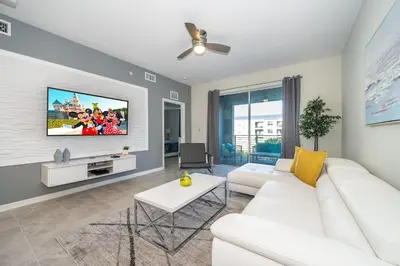 a living room with a white couch and a tv at 3180-305MN STOREY LAKE, CONDO 2/2 POOL VIEW in Kissimmee
