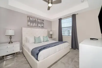 a white bedroom with a bed and a window at 3180-305MN STOREY LAKE, CONDO 2/2 POOL VIEW in Kissimmee
