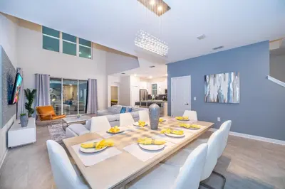 a dining room and living room with a table and chairs at 2825PA VILLA 5 BED/5 BA (SANITIZED) in Kissimmee