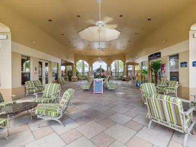 a lobby with chairs and tables and a ceiling at Ohana House at Windsor Hills, Disney World Luxury Rental in Orlando