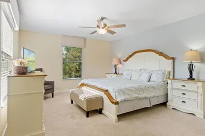 a bedroom with a bed and a ceiling fan at Spacious Vacation Home with Pool & Jacuzzi Near Disney in Kissimmee