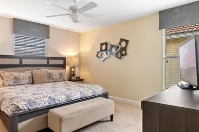 a bedroom with a bed and a flat screen tv at Spacious Vacation Home with Pool & Jacuzzi Near Disney in Kissimmee