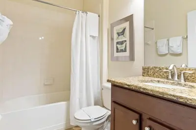 a bathroom with a sink and a toilet and a bathtub at Spacious Vacation Home with Pool & Jacuzzi Near Disney in Kissimmee