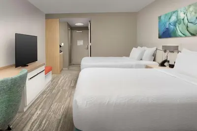 a hotel room with two beds and a flat screen tv at Hilton Garden Inn Orlando Downtown in Orlando