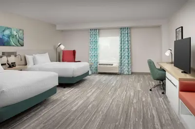 a hotel room with two beds and a television at Hilton Garden Inn Orlando Downtown in Orlando