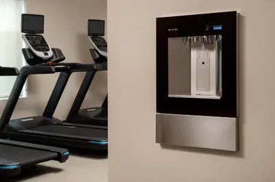a gym with three treadmills with cell phones at Home2 Suites by Hilton Orlando Downtown, FL in Orlando