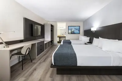 a hotel room with two beds and a desk at Avanti International Resort in Orlando