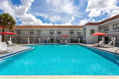 a large swimming pool in front of a building at Travelodge by Wyndham Orlando Lake Buena Vista South in Kissimmee