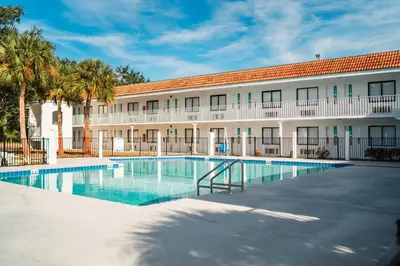 a hotel with a swimming pool in front of a building at Travelodge by Wyndham Orlando Lake Buena Vista South in Kissimmee