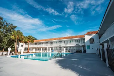 a view of the courtyard of a building with a swimming pool at Travelodge by Wyndham Orlando Lake Buena Vista South in Kissimmee