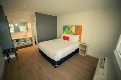 a small bedroom with a bed and a bathroom at Travelodge by Wyndham Orlando Lake Buena Vista South in Kissimmee