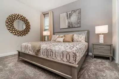a bedroom with a bed and a mirror at Villa wPrivate Pool &Themed Rooms, near Disney in Kissimmee