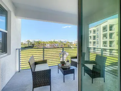 a balcony with chairs and a table on a balcony at Updated Condo, 5 mi to Disney, On-site Water Park in Kissimmee