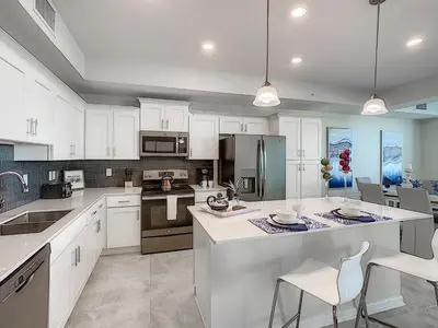 a kitchen with white cabinets and a large island at 3150 Paradox Circle 107 in Kissimmee