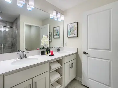 a bathroom with two sinks and a mirror at 3150 Paradox Circle 107 in Kissimmee