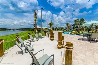 a group of chairs and tables next to a pool at 3150 Paradox Circle 107 in Kissimmee