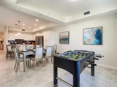 a dining room with a table and a chess board at Modern Condo near Disney Foosball Water Park in Kissimmee