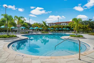 a pool at a resort with palm trees and umbrellas at Renovated Condo by Convention Center & I-Drive in Orlando