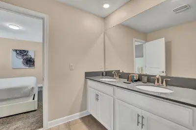 a bathroom with two sinks and a mirror at VILLA wPrivate Pool & Game Room near Disney in Kissimmee