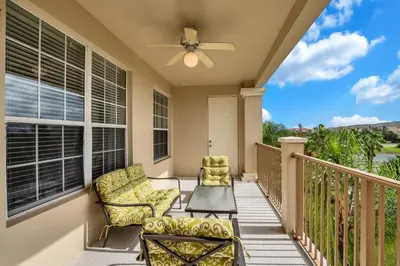 a balcony with two chairs and a ceiling fan at 4816 Cayview Ave #306 in Orlando
