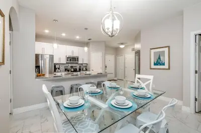 a dining room with a glass table and white chairs at 7664 Comrow Street #104 in Orlando