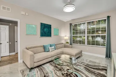 a living room with a couch and a glass table at 7664 Comrow Street #104 in Orlando