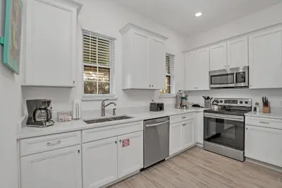 a white kitchen with white cabinets and appliances at Gorgeous Margaritaville Cottage wPrivate Patio in Orlando