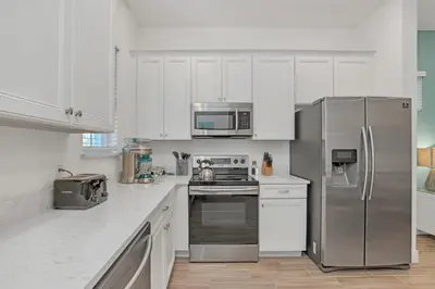 a kitchen with white cabinets and stainless steel appliances at Gorgeous Margaritaville Cottage wPrivate Patio in Orlando