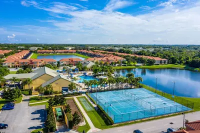 an aerial view of a resort with a tennis court and a lake at Spetacular TownHome With Private Pool close to Disney 8919PP in Kissimmee