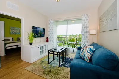 a living room with a blue couch and a table at Vista Cay at Epic Universe - Standard 3 bedroom penthouse in Orlando