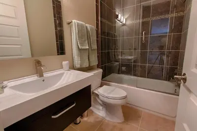 a bathroom with a sink and a toilet and a shower at Mickeys Atlantis - Luxury 8BR Mansion Oasis Pool Hot Tub Outdoor Kitchen Home Theater, Game Room & More! 2 Miles to Disney in Orlando