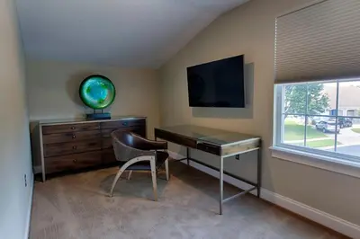 a desk and a chair in a room with a window at Mickeys Atlantis - Luxury 8BR Mansion Oasis Pool Hot Tub Outdoor Kitchen Home Theater, Game Room & More! 2 Miles to Disney in Orlando