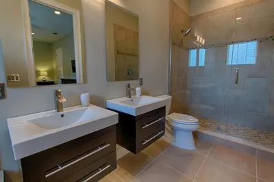 a bathroom with a sink and a toilet and a shower at Mickeys Atlantis - Luxury 8BR Mansion Oasis Pool Hot Tub Outdoor Kitchen Home Theater, Game Room & More! 2 Miles to Disney in Orlando