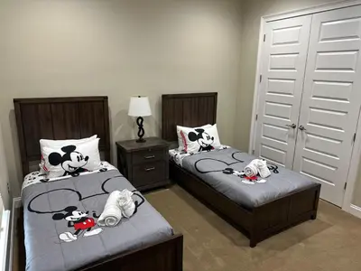 two beds with hello kitty pillows on them in a bedroom at Mickeys Atlantis - Luxury 8BR Mansion Oasis Pool Hot Tub Outdoor Kitchen Home Theater, Game Room & More! 2 Miles to Disney in Orlando