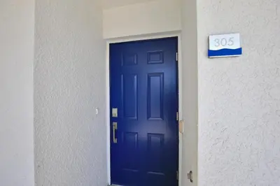 a blue door in a building with a sign on it at Beautiful apartment in lux Storey Lake community 10 miles to Disney! in Kissimmee
