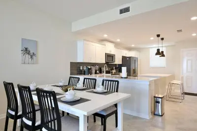 a kitchen and dining room with a white table and chairs at Beautiful apartment in lux Storey Lake community 10 miles to Disney! in Kissimmee