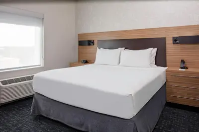 a large white bed in a hotel room at TownePlace Suites by Marriott Orlando Airport in Orlando