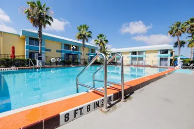 a swimming pool at a resort with palm trees at Garnet Inn & Suites, Orlando in Orlando